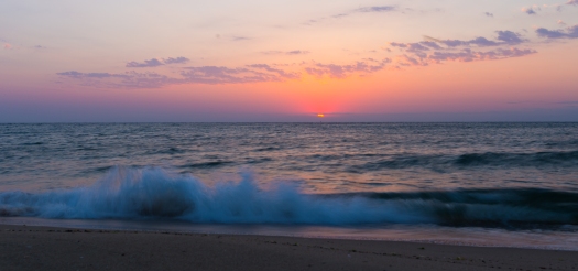 sunrise with wave breaking in foreground